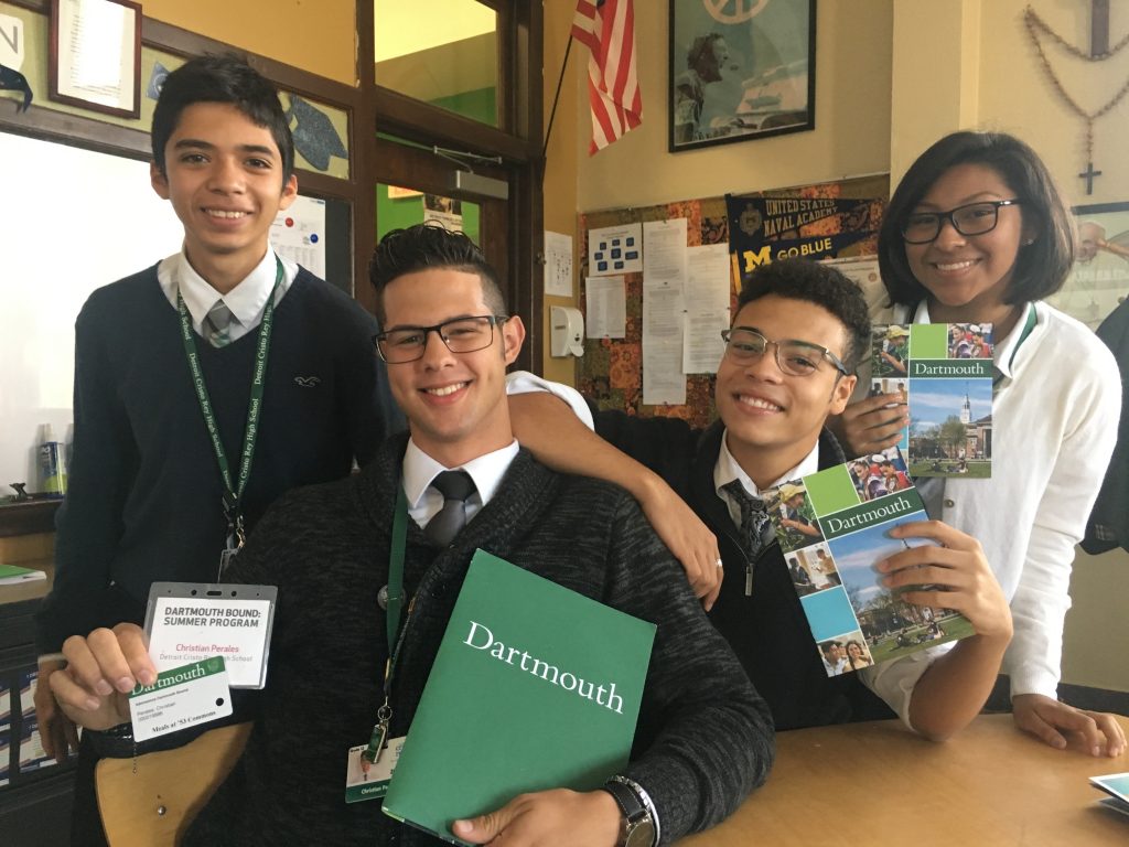 Four high school students hold Dartmouth brochures