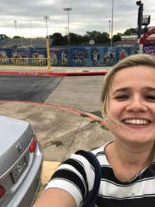 selfie of a young woman in front of a high school football stadium