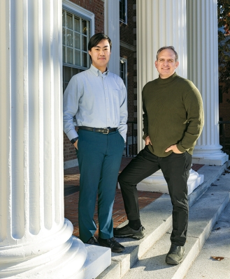 A photo of Carson Goh '25 and Jason Barabas '93 standing in front of white columns
