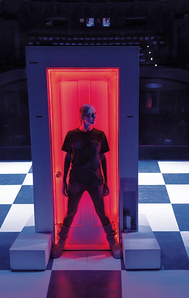 A photo of a person standing in front of a door set piece from the production of Pippin