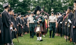 A photo of bagpiper Joshua Marks '96 leading a class to commencement