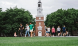  A photo of students walking on the Green with Baker Library in the background