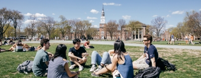 A photo of students sitting on the Green in small groups