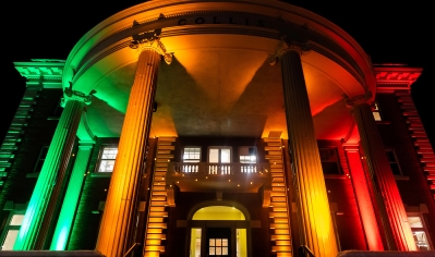 A photo of Collis Center lit in red, green, and gold in honor of Black Legacy Month