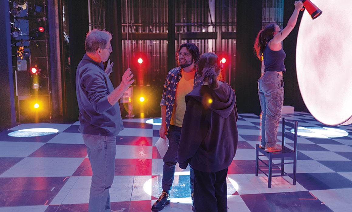 A photo of the lighting director talking with other members of the Pippin production