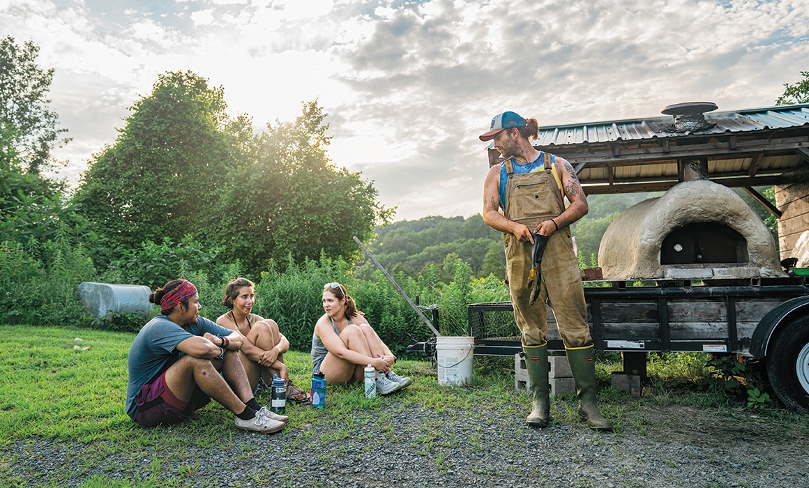 A photo of students hanging out near the pizza oven at Dartmouth's Organic Farm