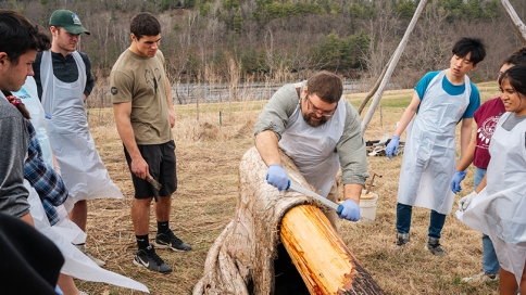 Art Hanchett, center, demonstrates how to process a moose hide in an “Encountering Forests” lab. 