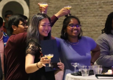 Angie with friends at the yearly Pan-Asian Gala. They are jokingly resting their drinks on each others' heads.