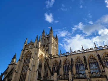 Bath Abbey: A church in gothic style shot from below under a clear blue sky. 