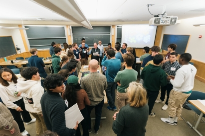 A crowd of Dartmouth students clustered around the board of a wargaming simulation.