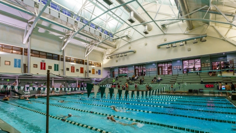 A landscape view of Dartmouth's pool at alumni gym. It's a standard multi-laned pool with deep blue water surrounded by bleachers.
