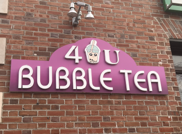 Pink sign reading "4U Bubble Tea" at the entrance of the bubble tea shop