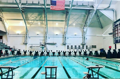 the empty Dartmouth pool with an American flag and championship banners hanging over it
