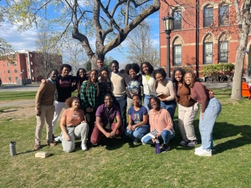 A group picture of students at the Black Christian Fellowship Convention taken outdoors in a sunny and grassy spot at Tufts University.