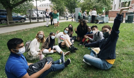 a group of people sitting on the grass