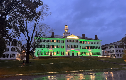 White building with green exterior lighting in the rain