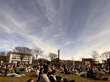 Picture of people observing the eclipse on the college green.