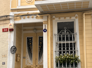 Entrance of the blogger's home in Istanbul. Yellow building with a big evil eye hanging from the entrance.