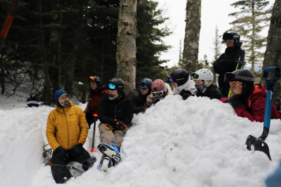 An image of all the participants making a snow pit, and studying snow stability 