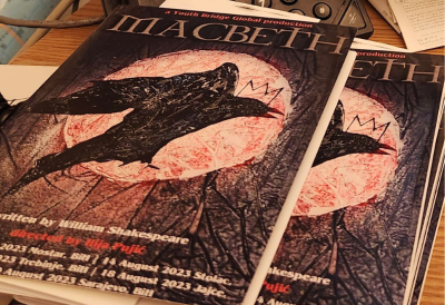 A series of program books titled Macbeth sitting on a desk. 