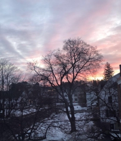 Missing my dorm room sunrise view The sun rising in the background with a snowy ground a white building in the foreground