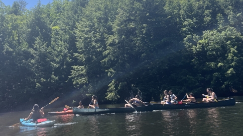 Native Americans at Dartmouth (NAD) and People of Color in the Outdoors (POCO) get together for a paddling trip; canoes and a couple kayaks are present.