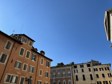 A photo of a few colorful apartment buildings in Rome against a clear blue sky