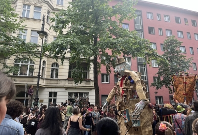 An image of a float at a street parade surrounded by many people