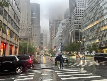 An image of a rainy afternoon on a crosswalk in the middle New York City 