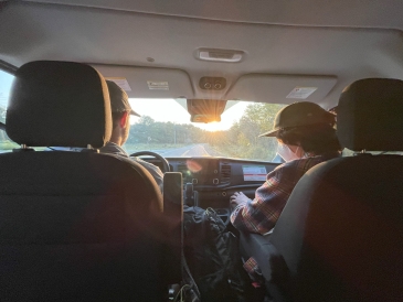 an image of Ian, driving, and Levi in the passenger's seat against the sunset light