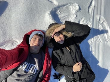 My friend and I laying down in the snow