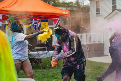 Two students play with colorful powder, a common celebration of the Caribbean Carnival.