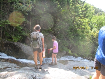 Two of Lily's fellow trippee's looking at the stream that goes over the rock face