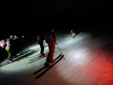 a picture of Kalina's friends, in full skiing gear, at night on the ski way