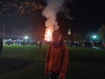 Lily at Homecoming Bonfire, Baker Tower in the background