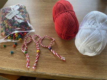 a picture of two balls of cotton and Bulgarian martenitsi (red and white bracelets)