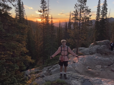 Martin posing in front of the sunset atop a mountain in Colorado.