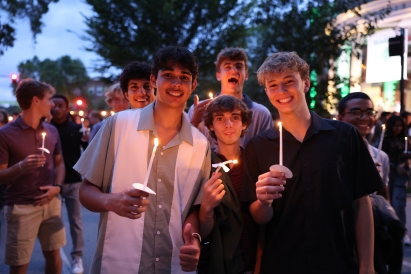Martin and some friends holding candles and posing at the candlelight ceremony