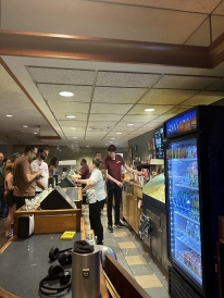 An over-the-counter picture of the Nugget Theater with employees handing out orders