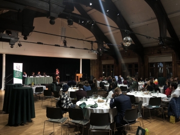 A panoramic shot of a dinner conference in the wood-paneled Collis Student Center 