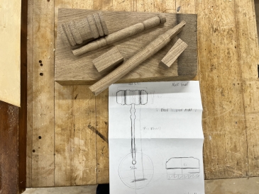 A picture of a block of wood, with the disassembled pieces of a gavel sitting on top of it. Below the block of wood is a drawing of the completed gavel.