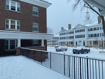 a picture outside martin's dorm of the parking lot, mid fayerweather dorm hall, and dartmouth hall. About a foot of snow rests on the ground!
