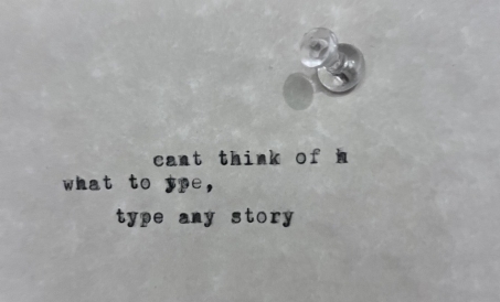 A piece of paper attached to a wall by a thumbtack. Written on the paper by a typewriter is: "cant think of h / what to ype, / type any story"