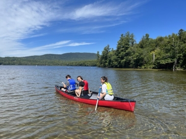 A picture of me and my trippees on a canoe in the middle of a lake. 