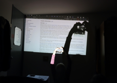 Image of a projected Wikipedia page with one of my friends making the heart sign over it