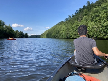 horizontal view of the connecticut river with a man paddling a canoe on the right