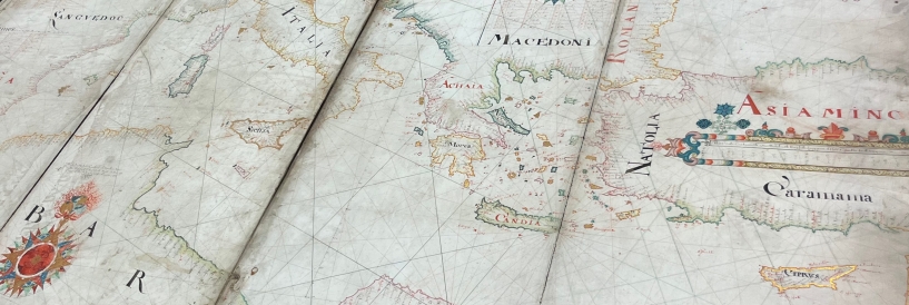 A zoomed-in photo of an old map book that shows a global view.