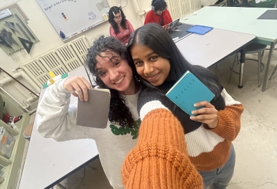 An image of two students holding small hand made books