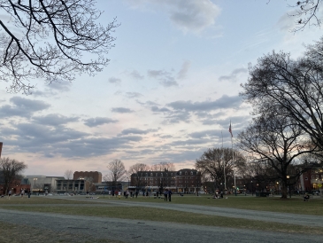 a picture of the Green at sunset with people sitting on the lawn