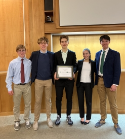 Dartmouth students in business attire holding a TuckLAB funding award.